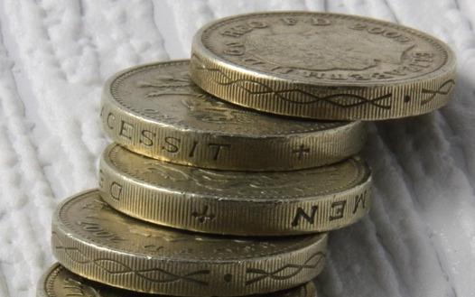 seven coins on a textured white surface
