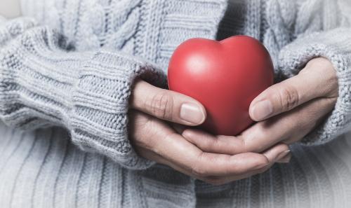 woman in winter dress holding heart