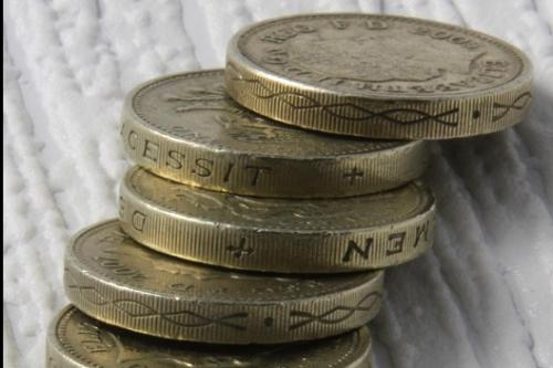 seven coins on a textured white surface