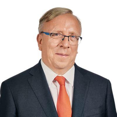 headshot of man in suit and orange tie